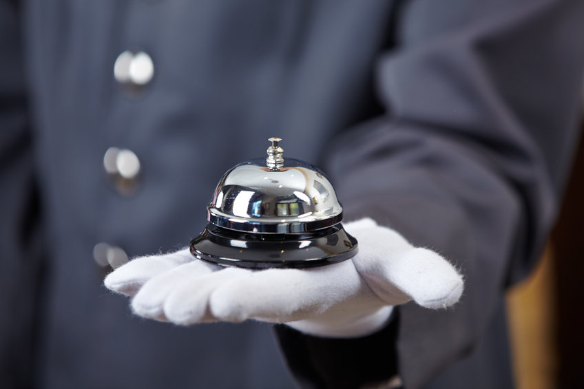 Hand of a concierge with a hotel bell